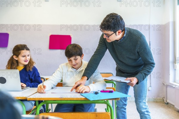 Teacher assisting students in the classroom, explaining concepts and correcting exercises while fostering a supportive learning environment
