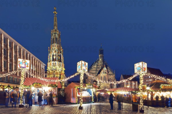 From left back: New Town Hall, Beautiful Fountain, Church of Our Lady, front: garlands, visitors, booths, stalls, illuminated, lights, in the evening, Advent season, Christmas season, Christmassy, romantic, traditional, Nuremberg Christmas Market, Main Market, Nuremberg, Middle Franconia, Franconia, Bavaria Germany