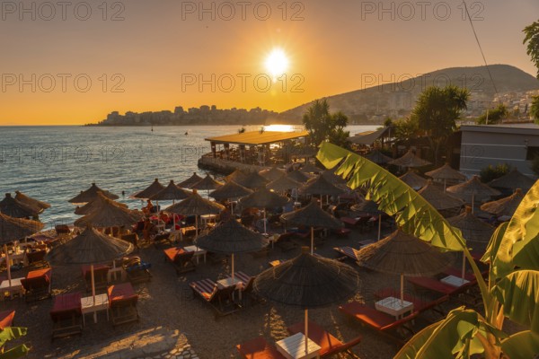 Beautiful resort with umbrellas by the sea at sunset in Sarande or Saranda on the Albanian riviera, Albania