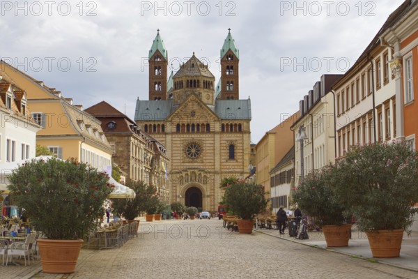 Historic architecture along a cobbled street, Speyer Cathedral in the background under clouds, Speyer