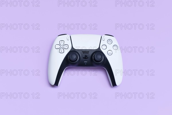 Germany - May 2025: White PlayStation 5 gaming controller on pastel violet background