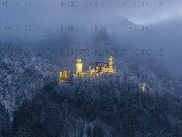 Fairytale castle surrounded by fog in a snow-covered mountain landscape, Neuschwanstein, Schwangau, Ostallgäu, Allgäu, Swabia, Upper Bavaria, Bavaria, Germany