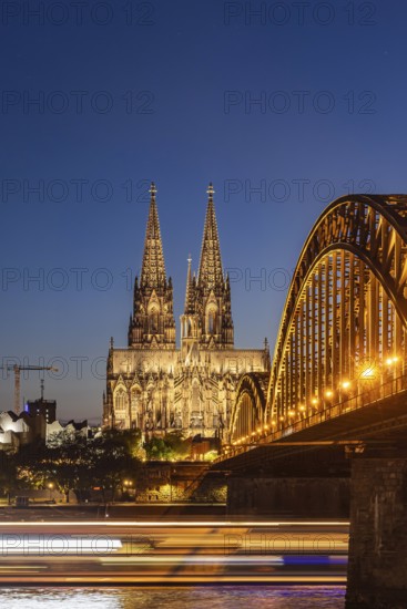 Cologne Cathedral, illuminated in the evening. Hohenzollern Bridge, railway bridge over the Rhine. City view of Cologne, North Rhine-Westphalia, Germany