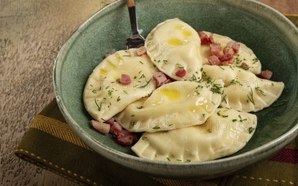 Dumplings, with fried prosciutto, a traditional dish of Polish cuisine, dumplings, top view, close-up, without people