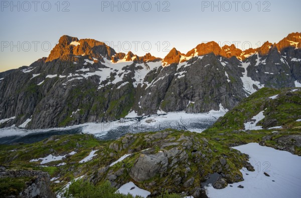 Rocky mountain peaks and Trollfjordvatnet with snow, at the Trollfjord Hytta, mountain landscape with alpenglow at sunrise, at the Trollfjord, Lofoten and Vesterålen, Nordland, Norway