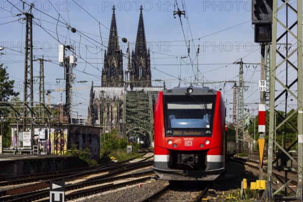 Regional train service operated by Deutsche Bahn between Cologne-Deutz and Cologne Central Station. Hohenzollern Bridge, railway bridge over the Rhine. The towers of Cologne Cathedral in the background. Cologne, North Rhine-Westphalia, Germany