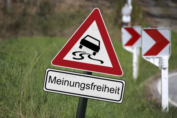 (Photomontage) : Traffic sign with danger of skidding, underneath a sign with the text MEINUNGSFREIHEIT