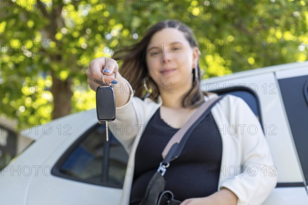 Proud businesswoman holding car keys in front of her new electric car, smiling with satisfaction and excitement over her recent purchase and the journey ahead