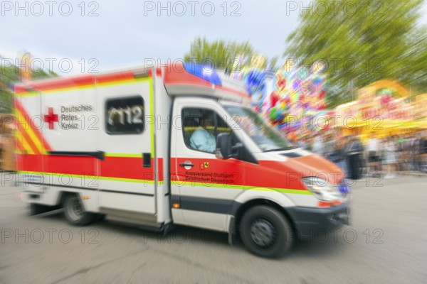 A German Red Cross ambulance drives quickly to an operation at the Cannstadter Volksfest, K Stuttgart, Baden-Württemberg