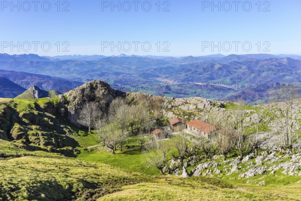 Scenic view of a mountain landscape featuring a traditional basque building nestled among trees, showcasing the beauty of the basque country