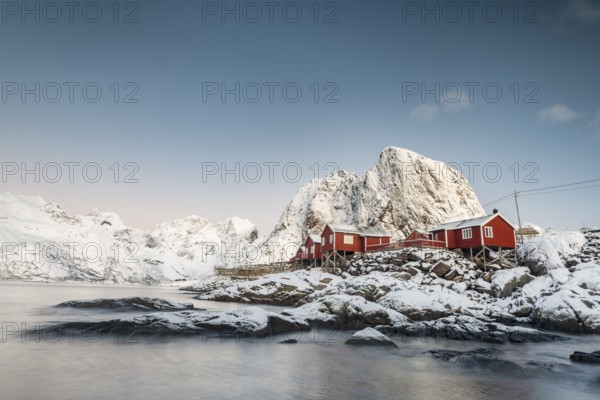 Town and fisherman's cabins or Rorbus in front of snowy mountains, winter, Hamnøy, Moskenesøy, Lofoten, Norway
