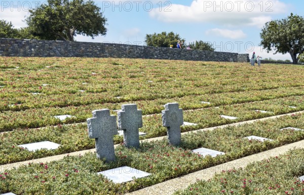 Three stone crosses between rows of grave slabs Gravestones Graves German soldiers' graves on part of German War Graves Commission inaugurated in 1974 by Volksbund Deutsche Kriegsgräberfürsorge German military cemetery on former battlefield in World War II heavily contested hill Height 107, Maleme, Crete, Greece