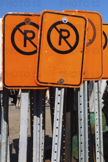 Close-up of fluorescent orange and black No Parking mobile street signs, Quebec, Canada