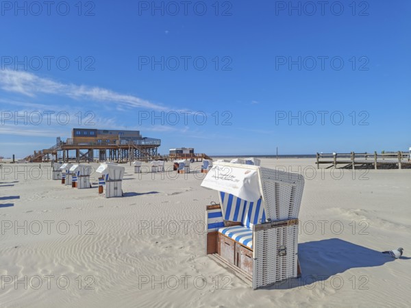 Preparing for the high season on the beach, setting up the beach chairs, North Sea, on the edge of the Wadden Sea National Park and UNESCO World Heritage Site, pile dwellings, sunshine and blue sky, SPO, Sankt Peter-Ording, Schleswig-Holstein, Germany