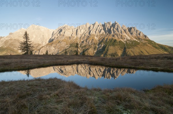 Mandlwände and left Hochkönig in morning light against lake with reflection, Salzburg, Austria