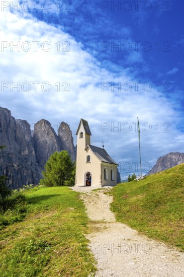 Small church at passo gardena with the dolomites in the background during a sunny summer day