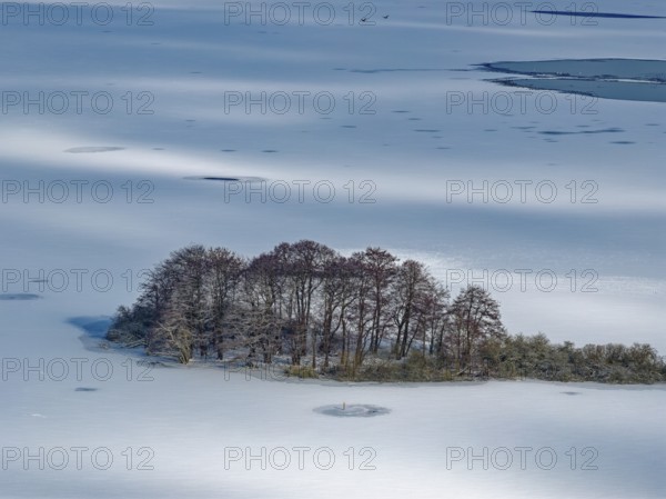 There is snow on the frozen Schaalsee near Zarrentin in the UNESCO Schaalsee Biosphere Reserve. In front is the island of Möwenburg. aerial view. Zarrrentin, Mecklenburg-Western Pomerania, Germany
