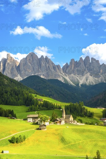 Scenic summer view of st. Magdalena church in val di funes with the odle mountain range in the background