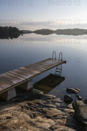 Wooden jetty with ladder, calm water surface, morning atmosphere, Kasnäsintie, Falkö Fjord, Kasnäs, Hitis archipelago, archipelago south of Turku, Finland