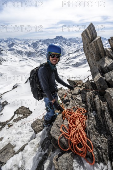 Mountaineer belaying with rope, climbing up a steep snow slope, belaying with rope, ascent to the summit of Piz Grialetsch in winter, view of mountain panorama with Piz Vadret with snow, Grisons Haute Route, Albula Alps, Rhaetian Alps, Grisons, Switzerland