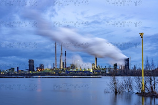 Rhine near Duisburg-Bruckhausen, industrial setting of the ThyssenKrupp steel plant, fire cloud of the Schwelgern coking plant, North Rhine-Westphalia, Germany