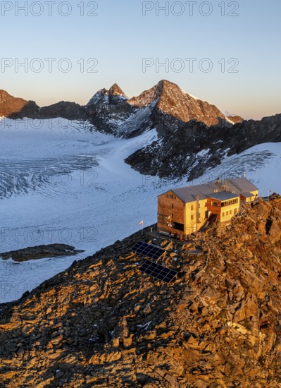Atmospheric sunrise in a picturesque mountain landscape, alpenglow, aerial view, mountain hut Becherhaus at the summit Becher and glacier Übeltalferner, Stubai Alps, South Tyrol, Italy