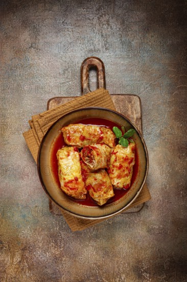 Stuffed cabbage rolls with minced meat, in tomato sauce, top view, without people, in the spotlight.