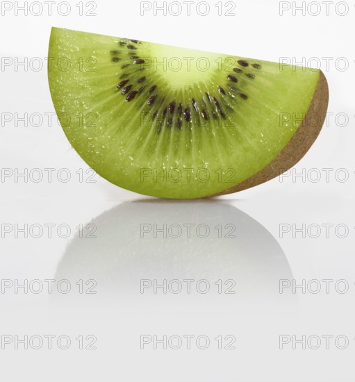 A quarter kiwi, kiwi fruit, Chinese gooseberry (Actinidia deliciosa) against a white background, studio photograph