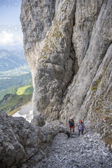 Two mountaineers with helmets climbing on a rock face, ascent to the Ackerlspitze, Wilder Kaiser, Kaiser Mountains, Tyrol, Austria