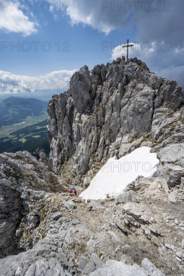 Mountain peak Ackerlspitze with summit cross, mountaineer on the last ascent to the summit, Wilder Kaiser, Kaiser Mountains, Tyrol, Austria