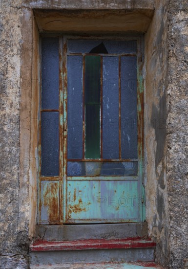Weathered glass entrance door, mountain village of Lakkoi, Crete, Greece