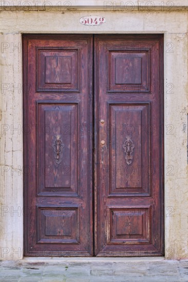 Door of an old house on 'Campo santa margherita' town square in Venice on a sunny day in winter, Italy