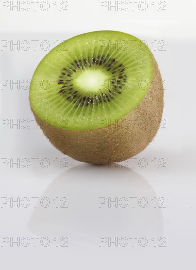 Half a kiwi, kiwi fruit, Chinese gooseberry (Actinidia deliciosa) against a white background, studio shot