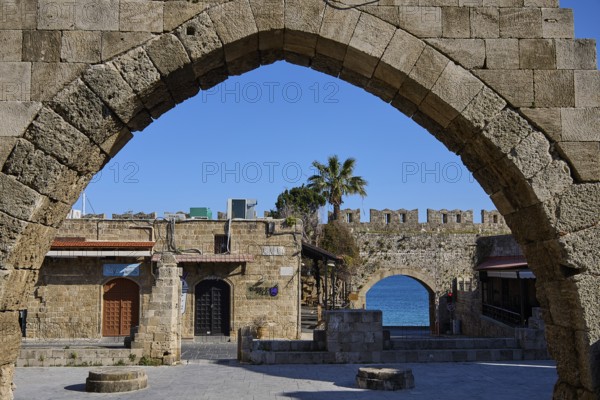 Arched wall overlooking the sea and historic buildings, Rhodes Old Town, Rhodes, Dodecanese, Greek Islands, Greece