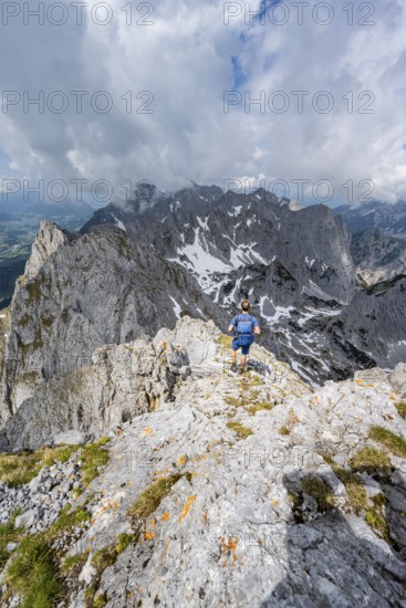 Mountaineer at the summit of the Ackerlspitze, view of rugged, rocky mountain landscape, view from the summit of the Ackerlspitze, mountain peak of the Wilder Kaiser, Kaiser Mountains, Tyrol, Austria