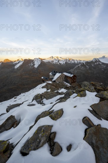 Snow-covered mountain landscape, mountain hut Ramolhaus in autumn with snow, at sunset, view of Gurgler Ferner with summit Hochwilde and Falschungsspitze, Ötztal Alps, Tyrol, Austria