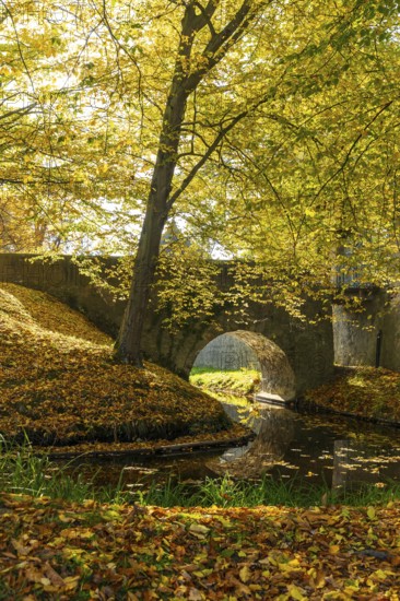 Bridge over the moat in the park of Hermsdorf Castle in autumn, Ottendorf-Ockrilla, Saxony, Germany