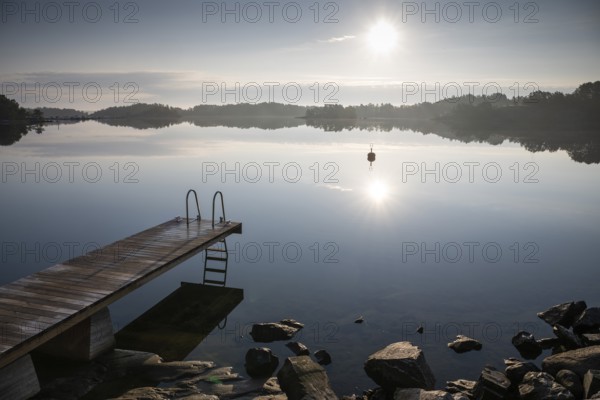 Wooden footbridge with ladder, sun reflected in the sea, morning mood, Kasnäsintie, Falkö Fjord, Kasnäs, Hitis archipelago, archipelago south of Turku, Finland