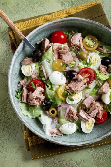 Salad with canned tuna, vegetable salad with quail eggs, lettuce, red onion, cherry tomatoes, olives, keto food, healthy food, homemade, no people