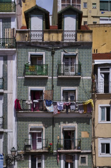 Residential building, house facade, narrow, azulejos, tiles, tile decoration, laundry for drying, balcony, old town, Lisbon, Portugal