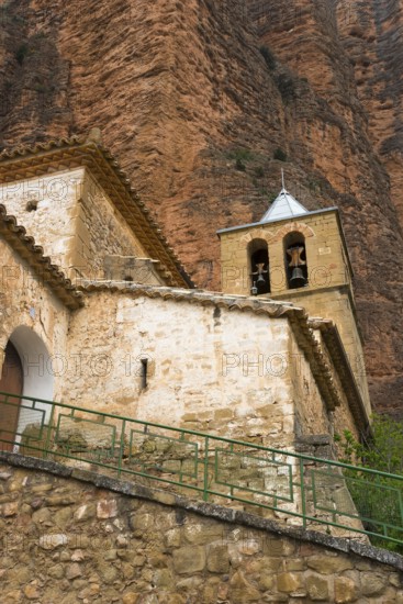 Old church with bell tower, embedded in a mountainous landscape with stone walls, Las Peñas de Riglos, As Penyas de Riglos, rock formation Mallos de Riglos, Huesca, Aragon, Spain