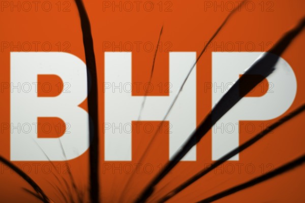 BHP logo is visible on the broken glass. BHP Group Limited is an Australian multinational mining and metals public company.