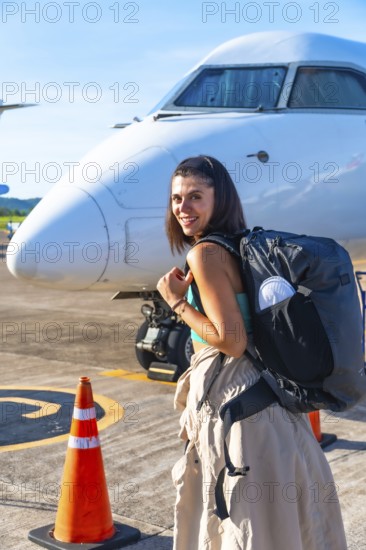 Young woman tourist with backpack arriving at francisco b. Reyes airport on coron island, ready to enjoy her philippines vacation