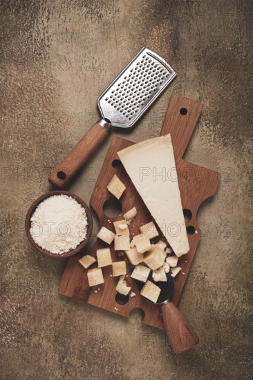 Freshly sliced and grated cheese, parmesan cheese, Gran gusto. Grana padano. on a wooden chopping board, rustic style, no people