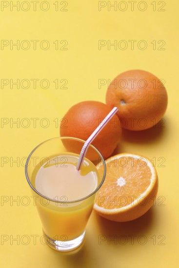 Orange juice in glass and oranges