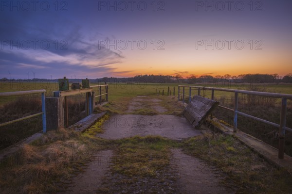 View of a sluice and a bridge with a pasture behind it at sunset, Kirchlinteln, Verden, Aller Leine Valley, Lower Saxony, Germany