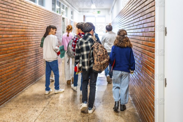 Group of elementary school students walking down the school hallway, chatting and laughing together as they transition between classes
