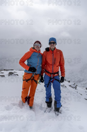 Two ski tourers, couple on the summit of the Köllkuppe or Cima Marmota, snow-covered mountain landscape, Ortler Alps, Vinschgau, Italy