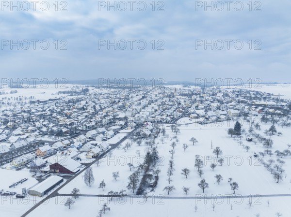 Snow-covered village with surrounding fields under a cloudy sky, Deckenpfronn, Böblingen district, Germany