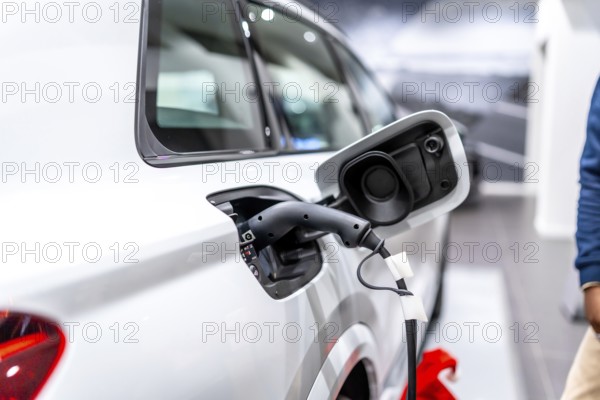 Close up of a charging electric car in a dealership, showcasing sustainable transportation